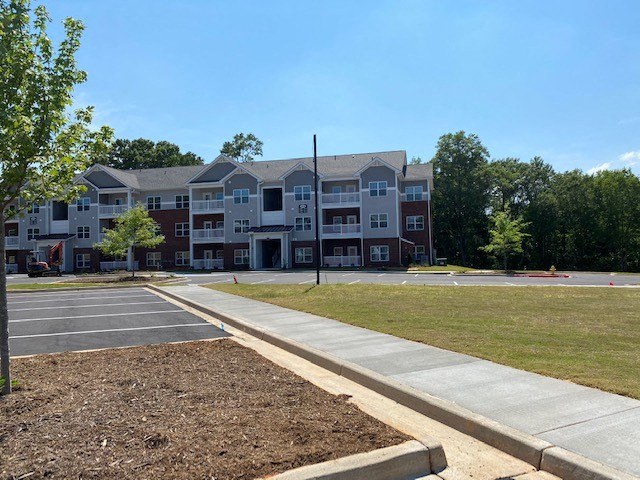 an empty parking lot in front of an apartment building